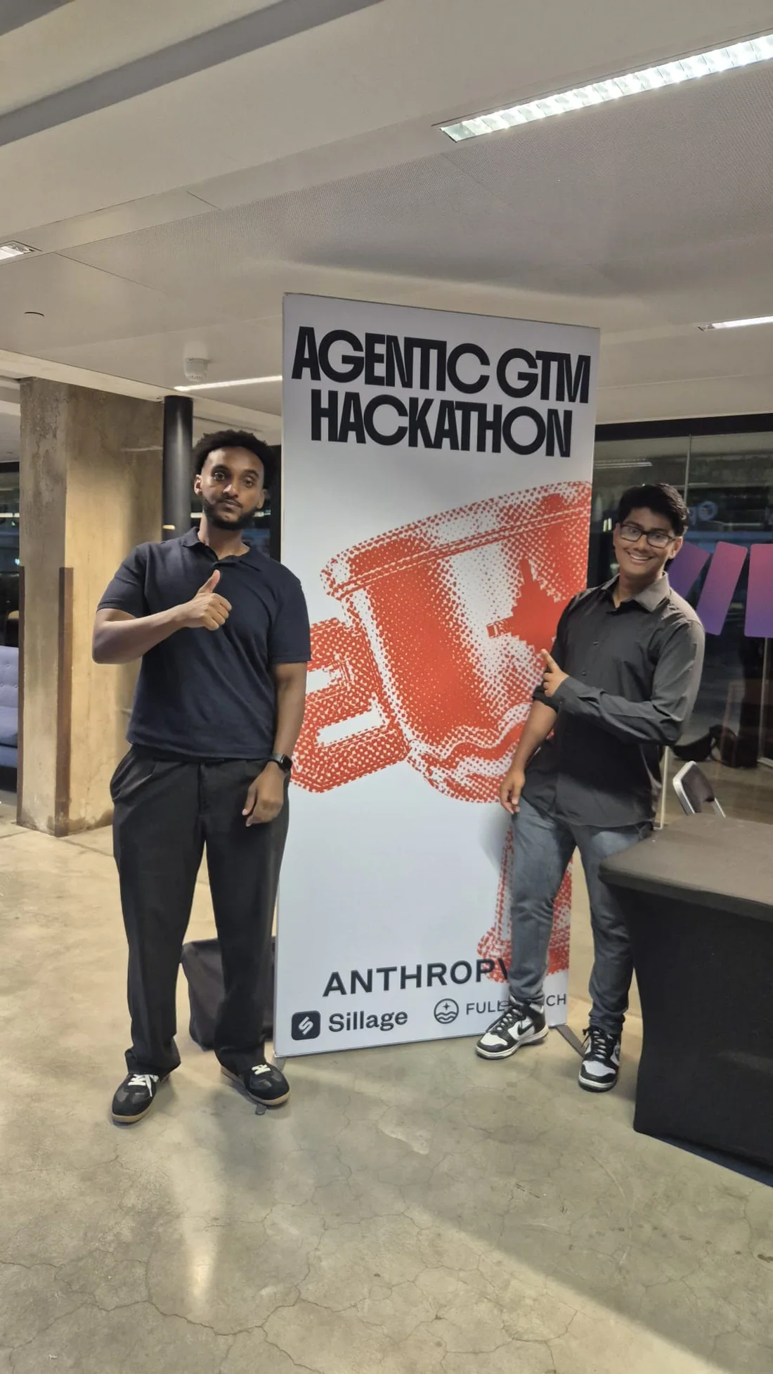 Two AI builders next to the Agentic GTM Hackathon banner in Amsterdam